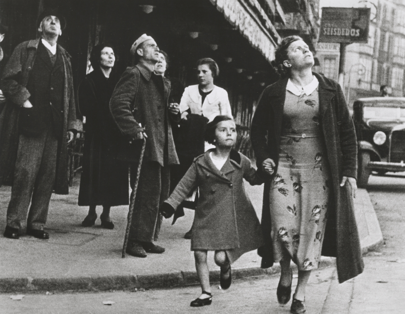 Woman and girl running for shelter on Gran Via during an air-raid, Bilbao, Spain, May 1937 Robert Capa / International Center of Photography / Magnum Photos / Capa Center – Budapest Photos: Hungarian Collection of The Robert Capa Photographs – Robert Capa Contemporary Photography Center, Budapest 